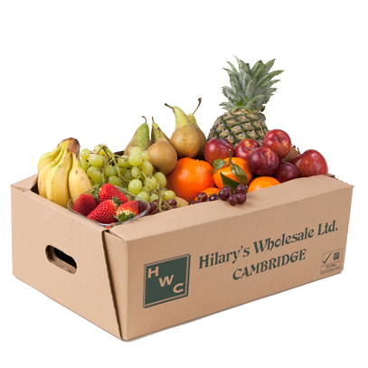 Cardboard box overflowing with fresh fruit, including pineapple, bananas, grapes, and oranges.